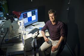 John Woodland sitting at his desk with surrounding equipment