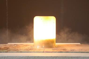 A small flash of heat, light and smoke contained within a large glass beaker