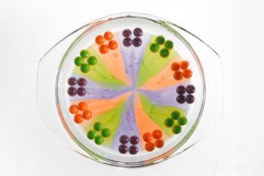 A glass dish with sweets around the edge whose colours have bled into the middle