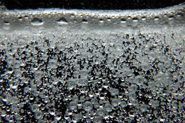 Lots of small bubbles in a clear liquid rising to the surface