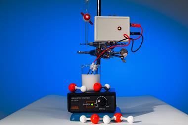 An experimental setup with a titration burette, a beaker of milky liquid, electrolysis electrodes and a magnetic stirrer