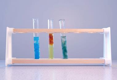 A photograph of three test tubes in a test tube rack, each containing a different colour of precipitate including copper hydroxide, iron(III) hydroxide and iron(II) hydroxide
