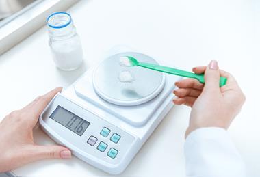 An image of a person weighing out a reagent on a balance scale