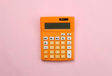 A photograph of an orange calculator on a pink background