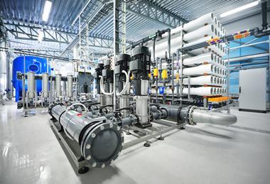 Inside a reverse osmosis plant with a collection of pipes and machinery.