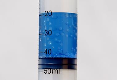 A test tube of boiling water at room temperature, with blue food dye for clarity