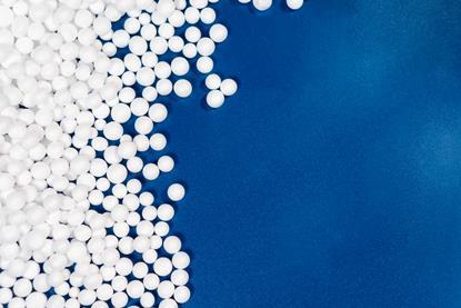 Numerous expanded polystyrene foam beads on a blue background