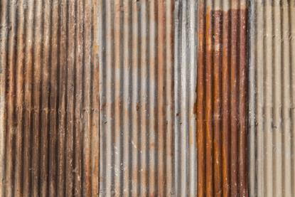 A full-frame photograph of panels of rusty corrugated iron