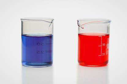 Two glass beakers containing red and blue liquids