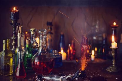Lit candles and a spooky selection of bottles holding coloured liquids