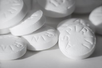 Macro photograph of white tablets marked with the word aspirin