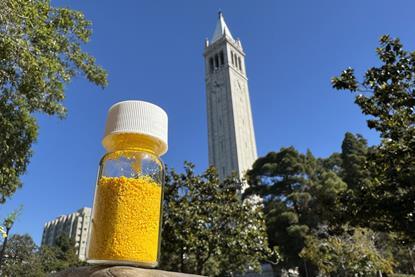 A bright yellow powder in a closed glass jar in front of a university clock tower