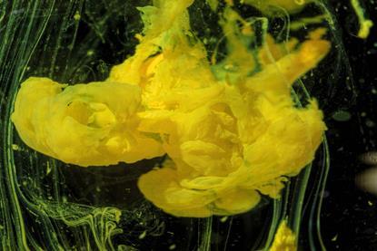 A yellow precipitate forming in a clear liquid against a black background