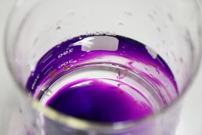 A photograph showing potassium permanganate in a glass beaker