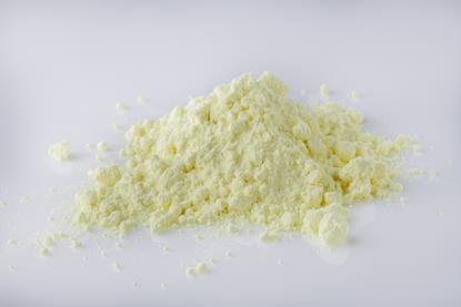 A small heap of purified yellow sulfur powder against a neutral background