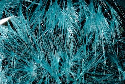 A photograph showing blue copper chloride crystals against a black background