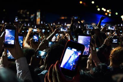 People at a concert taking photos on their mobile phones