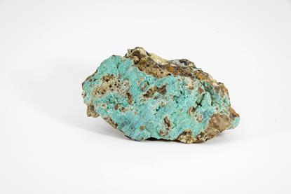 A close-up photograph of a sample of copper ore, with patches of a distinctive blue-green colour, against a neutral background
