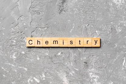 A photograph of wooden tiles with letters spelling the word 'chemistry'
