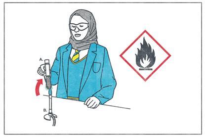 A girl in school uniform with a headscarf heats a testube of liquid over a bunsen burner
