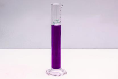 A glass measuring cylinder containing a dark purple liquid