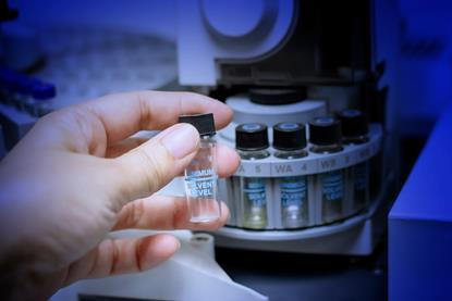 Close up of a hand holding a vial