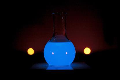 A round glass flask glowing blue