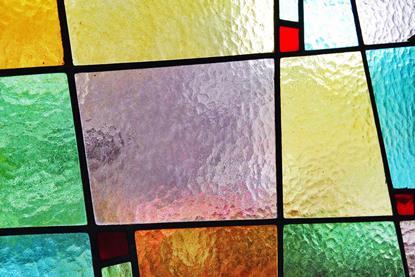 A close-up, full-frame photograph of multicoloured stain glass panels
