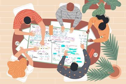 Students studying together around a poster on a table