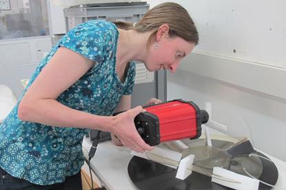 A photo of Katherine Curran working as a conservator at a museum
