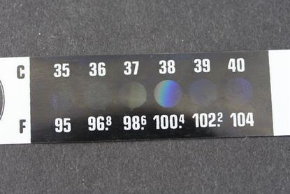 A thermometer strip with Celsius and Fahrenheit scales, currently indicating a temperature of 38 degrees Celsius