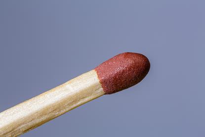A macro photograph of the head of an unlit matchstick