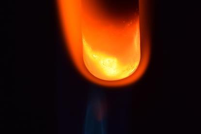 A photograph of a glass tube containing magnesium and copper oxide; the tube has been heated and glows as a reaction takes place.