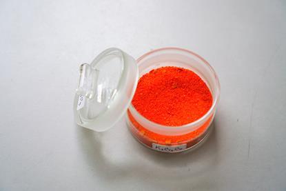 A photograph of orange potassium dichromate(VI) in a clear glass container