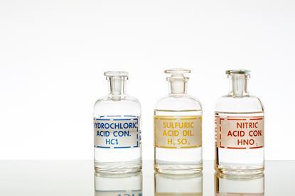 A photograph showing three labelled flasks containing hydrochloric acid, sulfuric acid and nitric acid