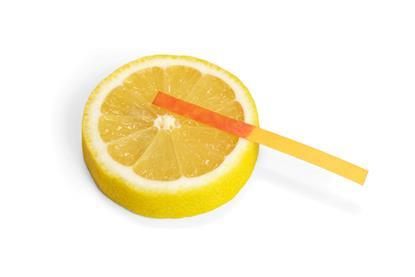 Testing a slice of lemon with litmus paper