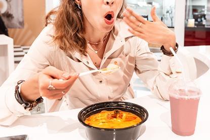 A photo of a woman reacting to eating spicy food