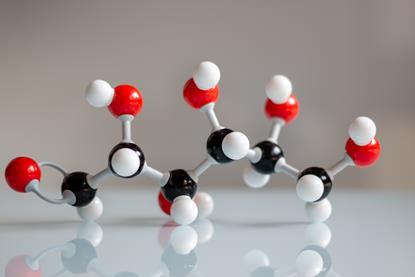 Close-up of a plastic molecular model of a glucose model, on a white table top