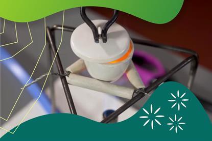 Tongs are lifting the lid from a crucible revealing a glowing reaction inside with green graphic surround