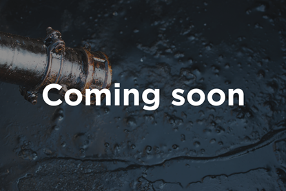 A photograph of crude oil below a metal pipe, with superimposed text reading "Coming soon"