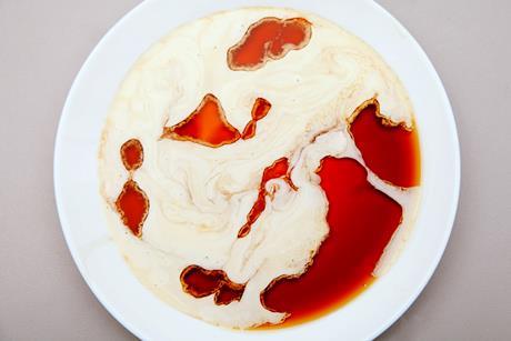 A dish with a mottled pattern of a milky cream liquid in a clear brown liquid