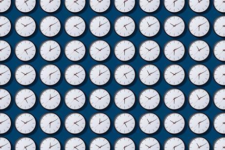 Rows and rows of identical clock faces showing different times