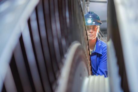 A female engineer inspects a turbine in a nuclear power plant