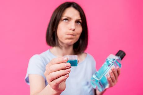 A woman rinsing her mouth with mouthwash