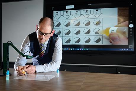 A teacher demonstrates a Microscale experiment via a projector on a large screen