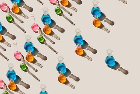Lines of laboratory glassware containing colour liquids. Each line has fewer items in it.