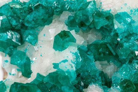 A macro photograph of blue-green dioptase crystals