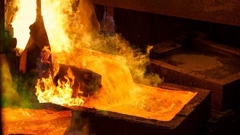Molten metal pours from a furnace into a mould