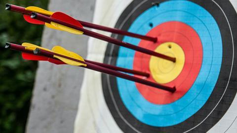 Four arrows embedded in an archery target