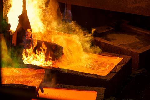 Molten metal pours from a furnace into a mould